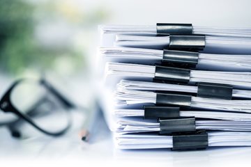 Document Center Image of a stack of documents with a pair of glasses and pencil