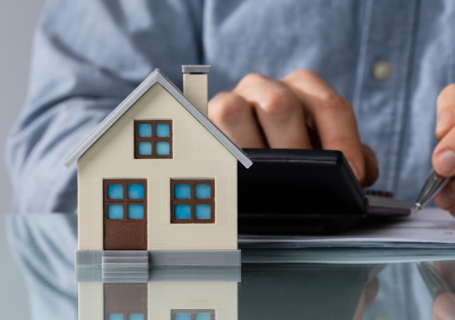 Image of a house and a hand on a calculator